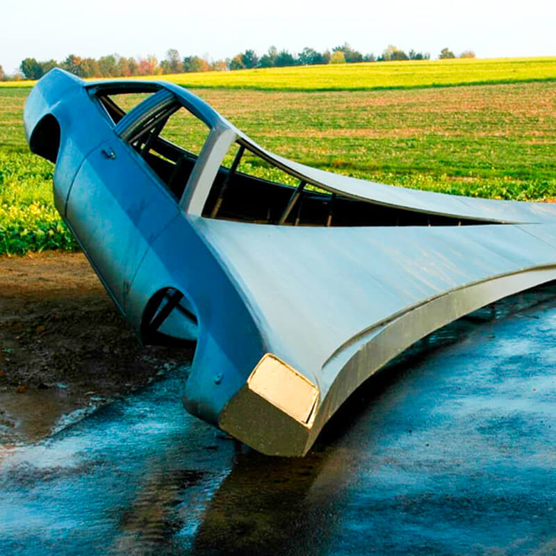 Ein zersägtes Auto - ein Manta - mit 18 m langen Ausläufern, die sich dynamisch um eine Kurve legen und im Boden verhaftet sind
