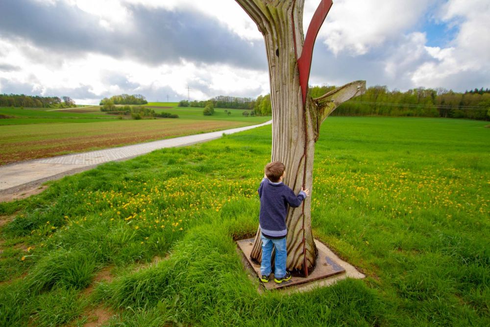 Kind an der Skulptur