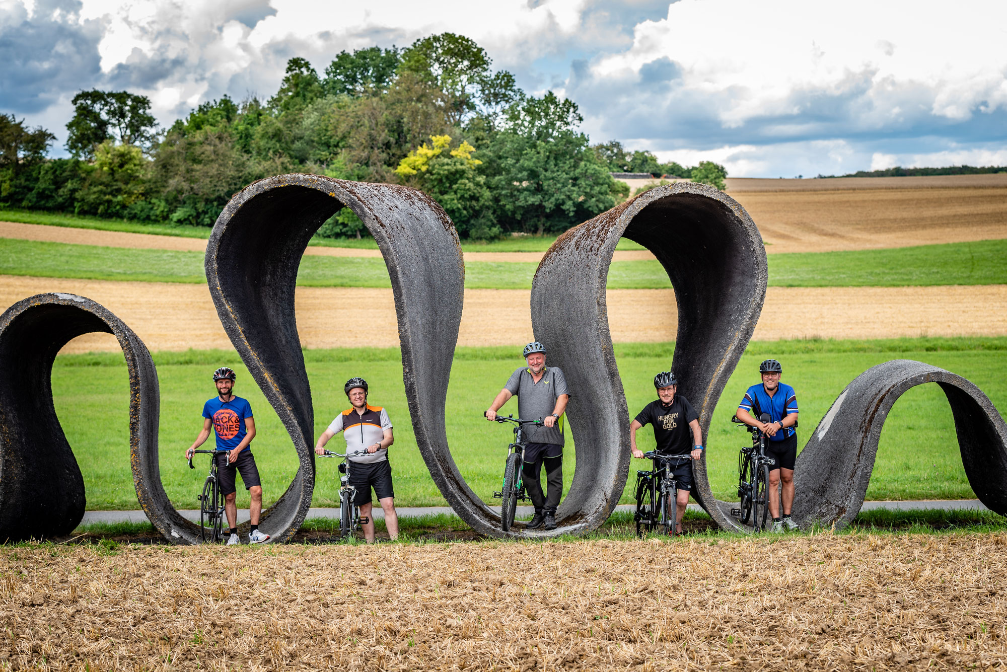 Die B&uuml;rgermeister der RIO Gemeinden mit ihren Fahrr&auml;dern vor der Stra&szlig;enskulptur